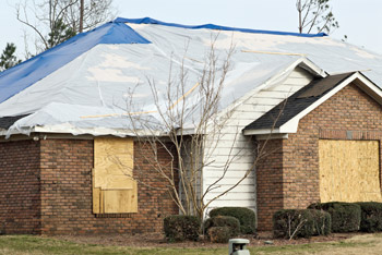 House board up and tarping after a tornado